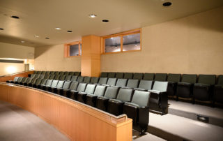 Proshansky Auditorium - Auditorium Rental in NYC. Plush seating in back of auditorium, and window to the lighting and sound booth.