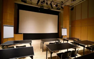 Segal Theatre - Black Box Theater Rental in NYC. Set up classroom style, looking towards front of the theater space.